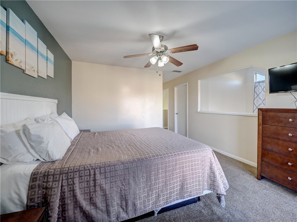 14300 Aloha Street, Unit 151 Corpus Christi, TX 78418 - Photo 22 of 33 a bedroom with a bed and a chandelier