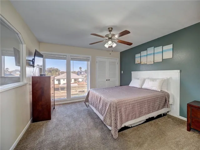 a bedroom with a bed chandelier and a window