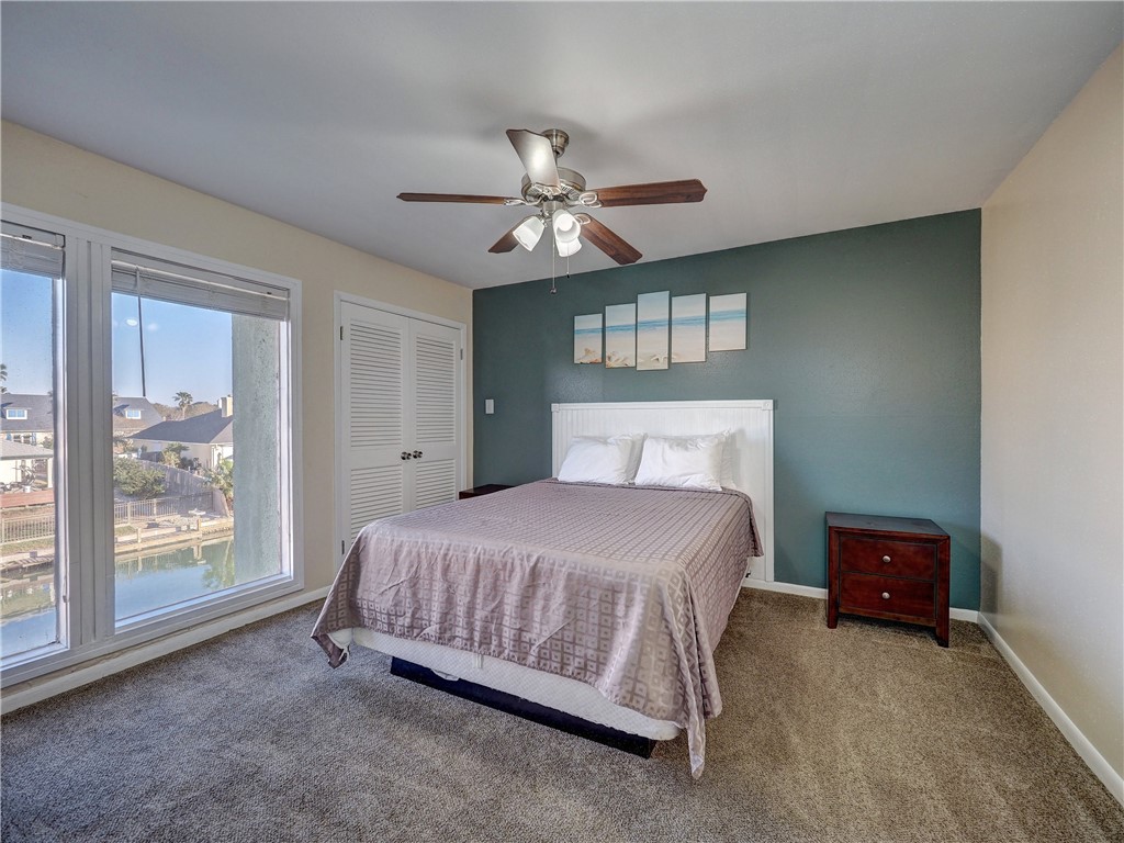 14300 Aloha Street, Unit 151 Corpus Christi, TX 78418 - Photo 24 of 33 a bedroom with a bed chandelier and a window