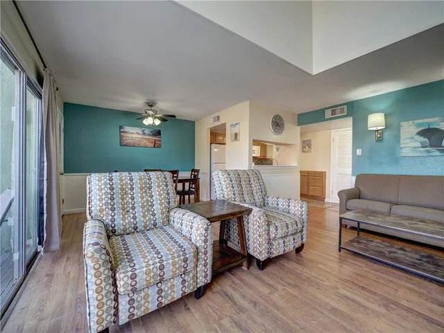 a living room with furniture a flat screen tv and a large window