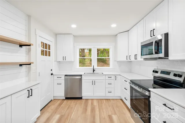 a kitchen with a sink stove microwave and refrigerator