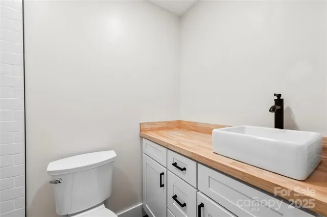 a bathroom with a granite countertop toilet and a sink