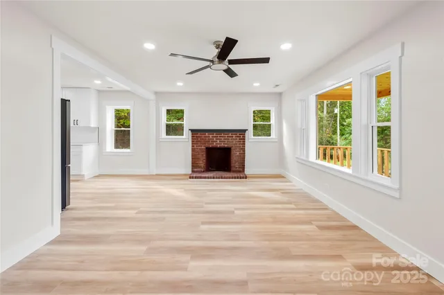 a view of an empty room with window and fireplace