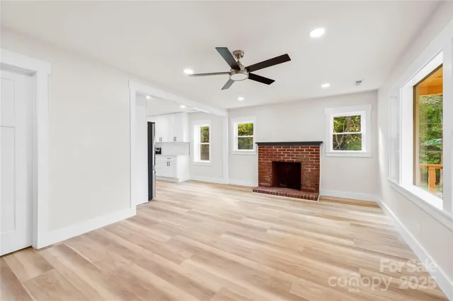 a view of an empty room with a fireplace and a window