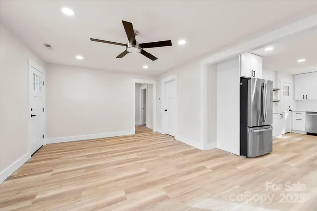 a view of empty room with wooden floor and window