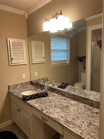 a bathroom with a granite countertop sink and a wooden cabinets