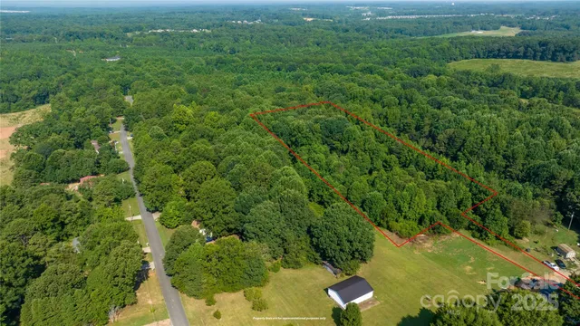 an aerial view of residential houses with outdoor space and trees
