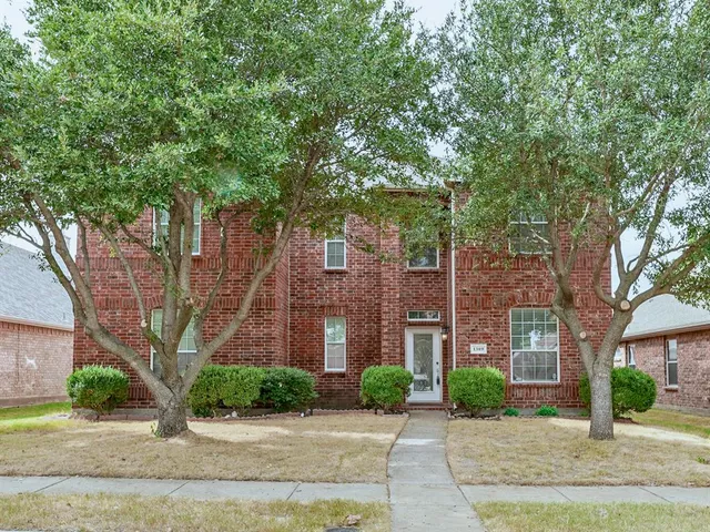 front view of a brick house next to a yard