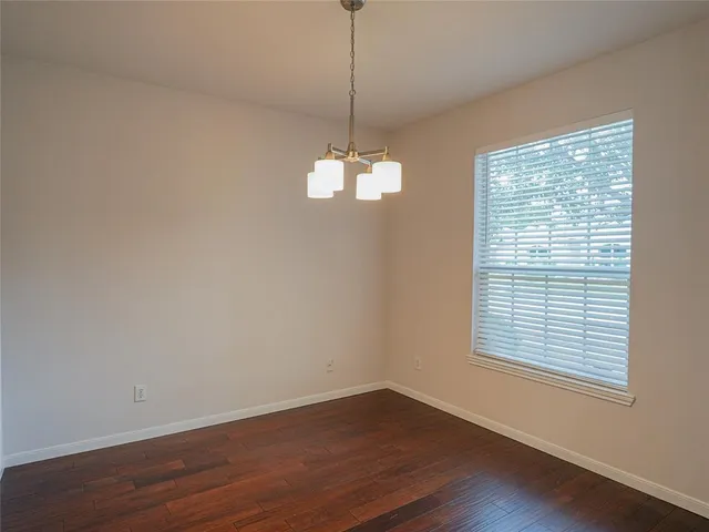 a view of a room with wooden floor exposed radiator and windows