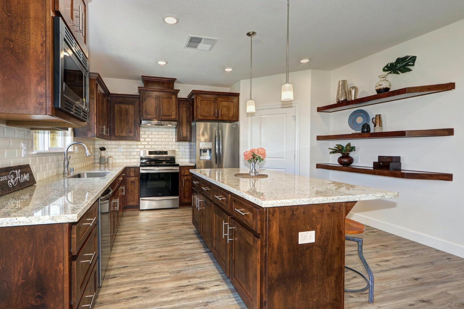 932 Norman Road Galt, CA 95632 - Photo 12 of 21 a kitchen with stainless steel appliances granite countertop a sink a stove and a refrigerator