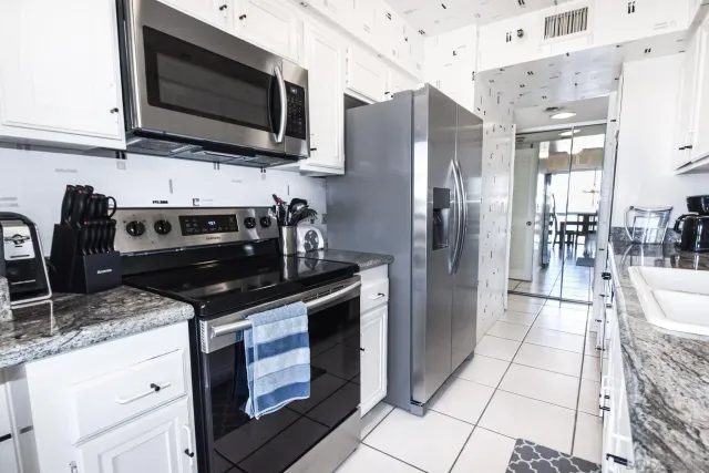 a kitchen with stainless steel appliances granite countertop a stove microwave and refrigerator