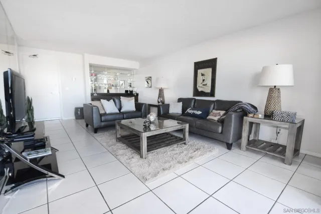 a living room with furniture a flat screen tv and a window