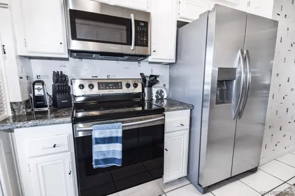 a kitchen with stainless steel appliances granite countertop a refrigerator stove and microwave