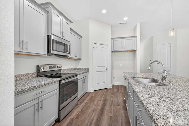 a view of a kitchen with wooden floor and a kitchen