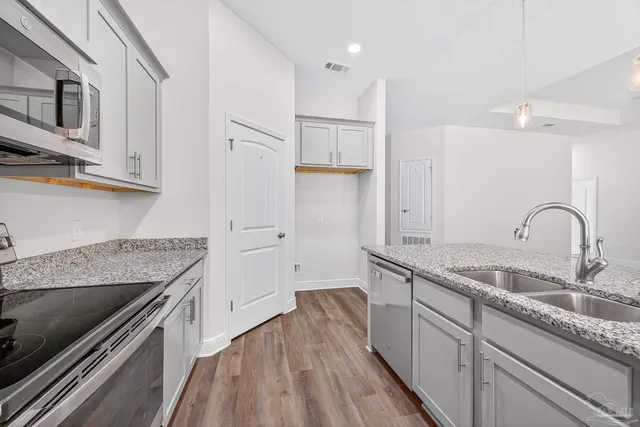 a kitchen with kitchen island granite countertop a sink and a stove