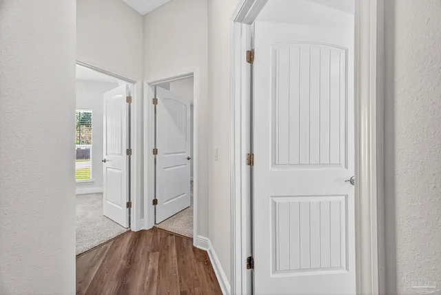 a view of a hallway with wooden floor and staircase