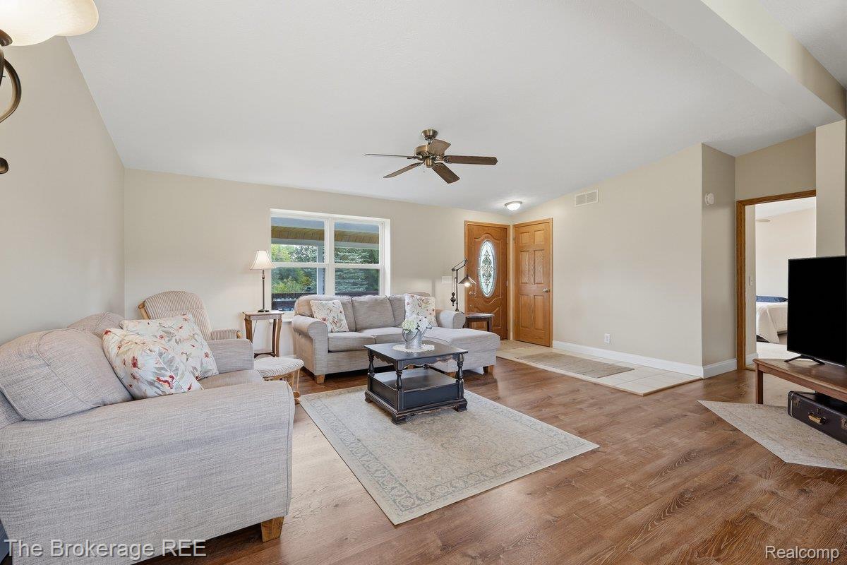 2422 South Henderson Road Davison, MI 48423 - Photo 18 of 53 Vaulted ceiling, wood-finish flooring, ceiling fan, natural wood front door with oval glass insert, and large windows