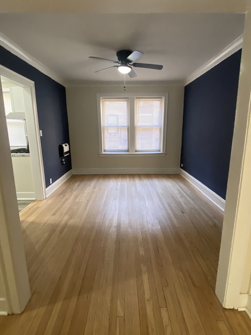 2210 East 70th Street, Unit 1 Chicago, IL 60649 - Photo 11 of 15 a view of an empty room with wooden floor and a window