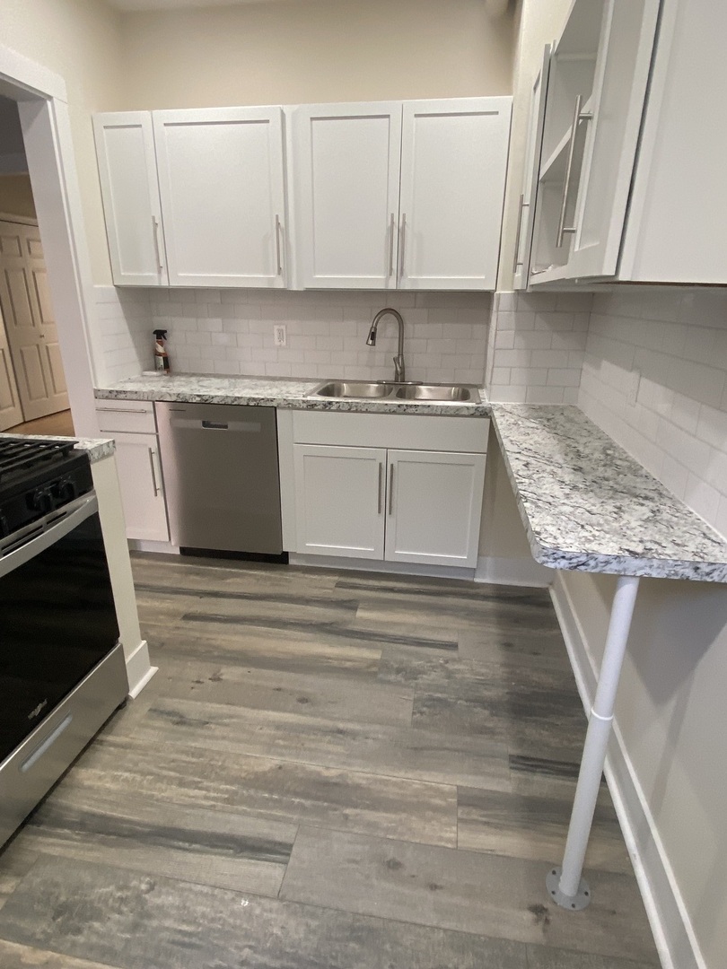 2210 East 70th Street, Unit 1 Chicago, IL 60649 - Photo 13 of 15 a kitchen with a sink stove and cabinets