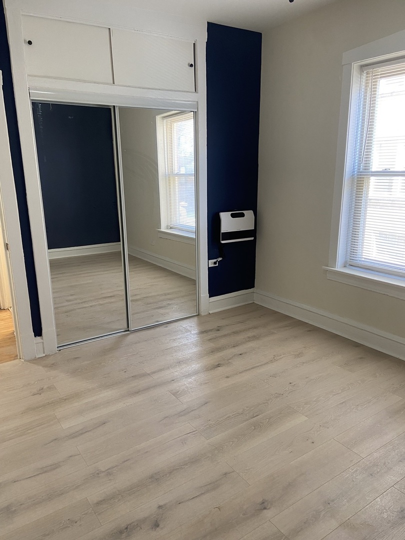 2210 East 70th Street, Unit 1 Chicago, IL 60649 - Photo 4 of 15 an empty room with windows