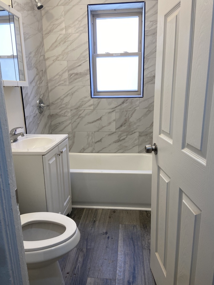 2210 East 70th Street, Unit 1 Chicago, IL 60649 - Photo 5 of 15 a bathroom with a toilet and a tub