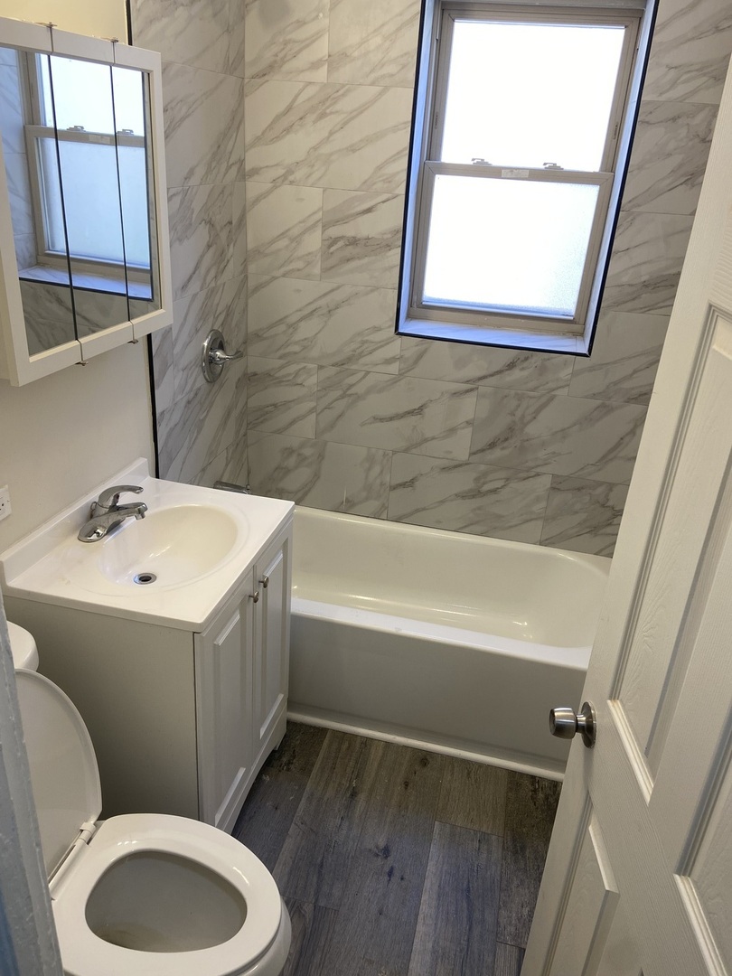 2210 East 70th Street, Unit 1 Chicago, IL 60649 - Photo 6 of 15 a bathroom with a sink toilet and shower