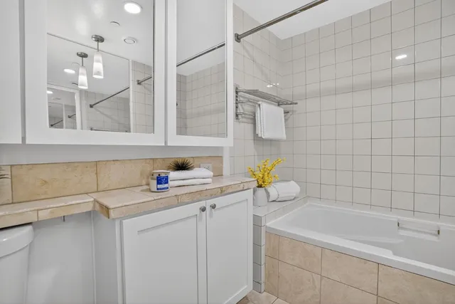 a bathroom with a granite countertop sink a toilet and bathtub