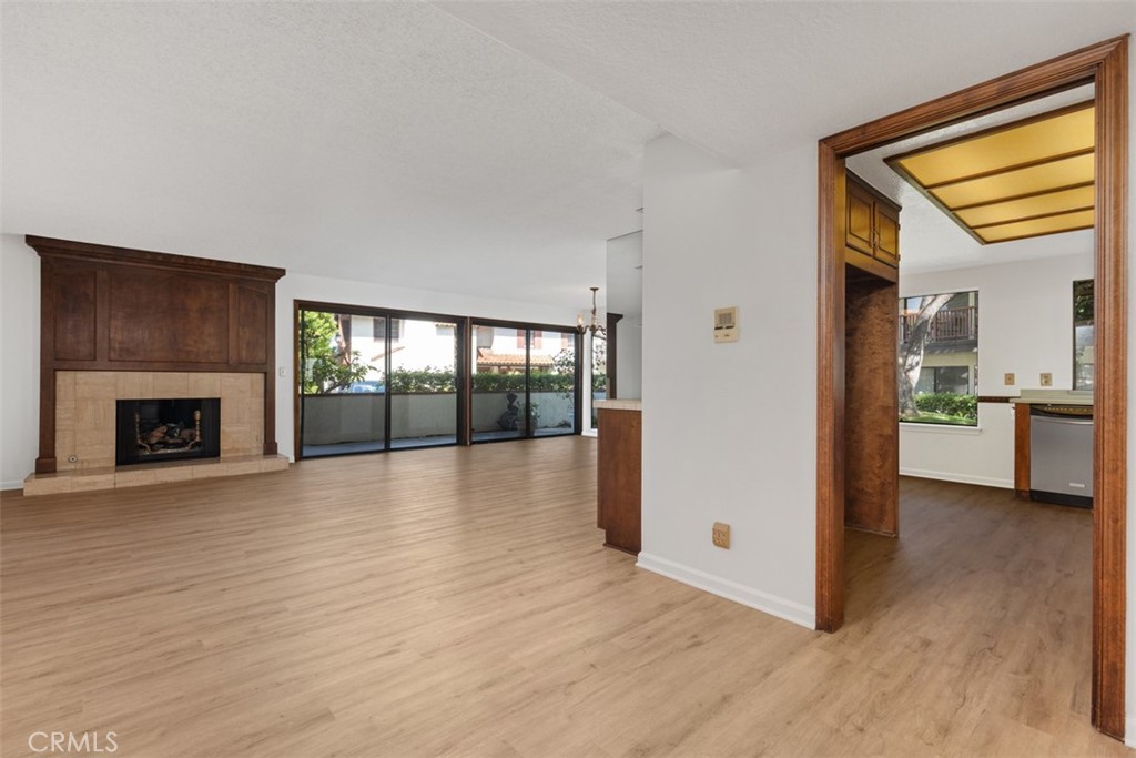 a view of a livingroom with wooden floor and a fireplace