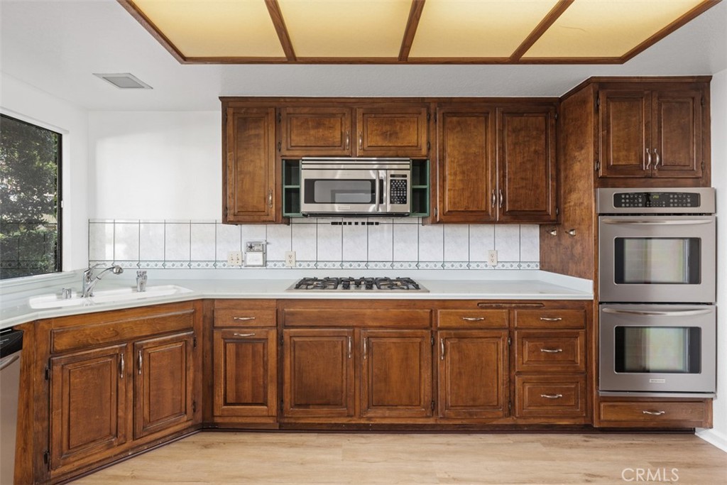 6200 Riviera Circle Long Beach, CA 90815 - Photo 11 of 35 a kitchen with stainless steel appliances granite countertop wooden cabinets and a stove top oven