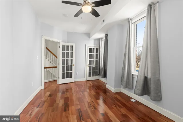 a view of a livingroom with wooden floor and ceiling fan