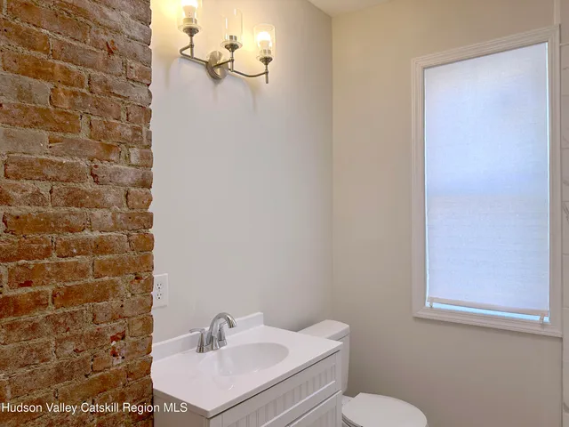 a bathroom with a sink a toilet and mirror