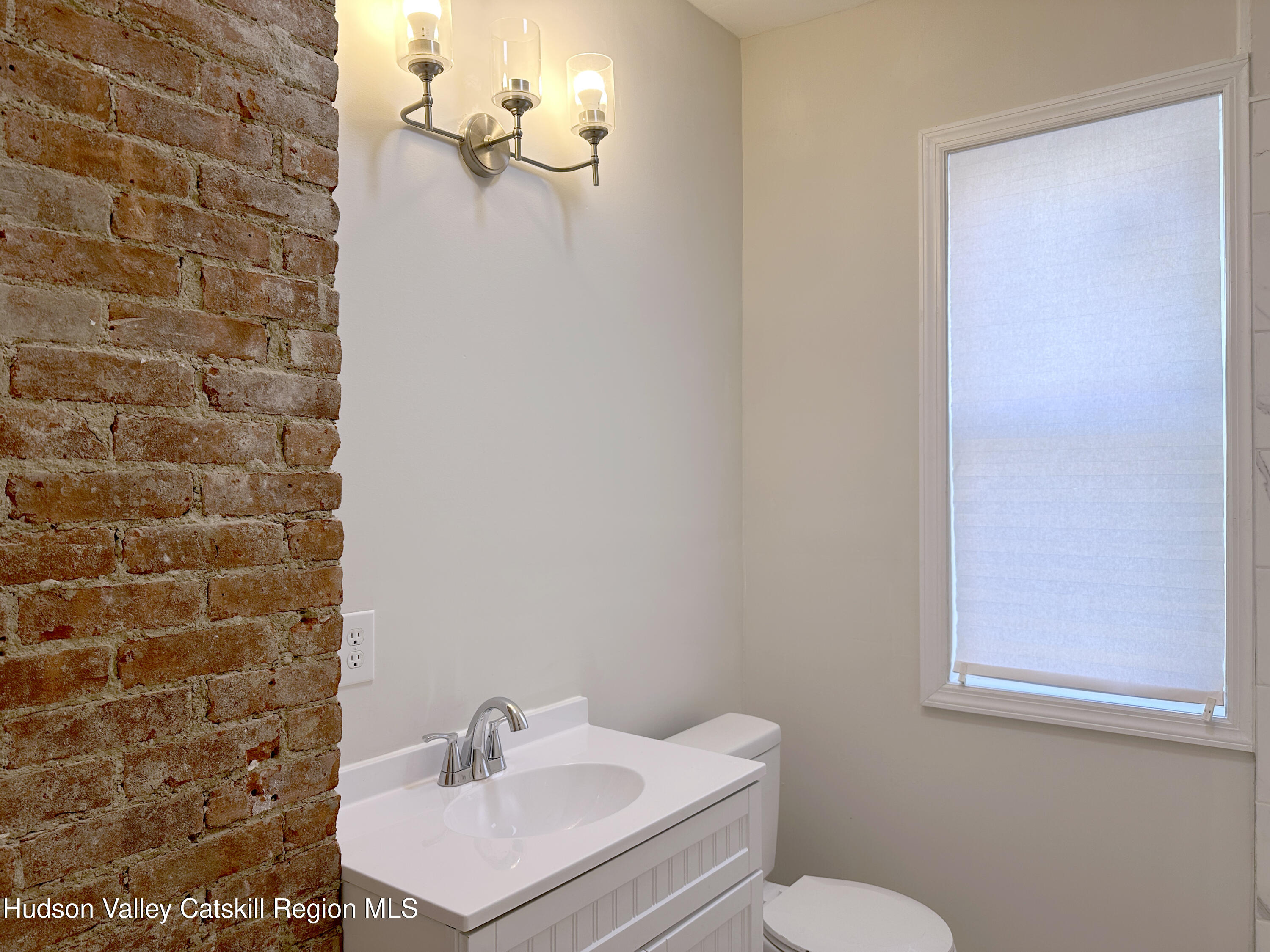 228 Mansion Street Poughkeepsie, NY 12601 - Photo 12 of 35 a bathroom with a sink a toilet and mirror