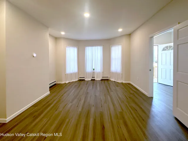a view of a room with wooden floor and window