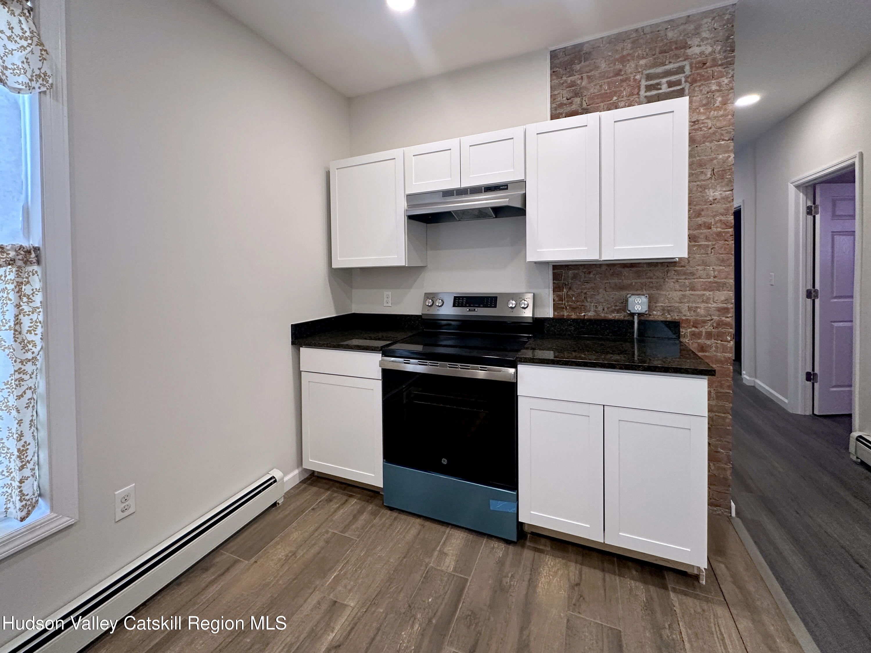228 Mansion Street Poughkeepsie, NY 12601 - Photo 9 of 35 a kitchen with granite countertop white cabinets and black appliances
