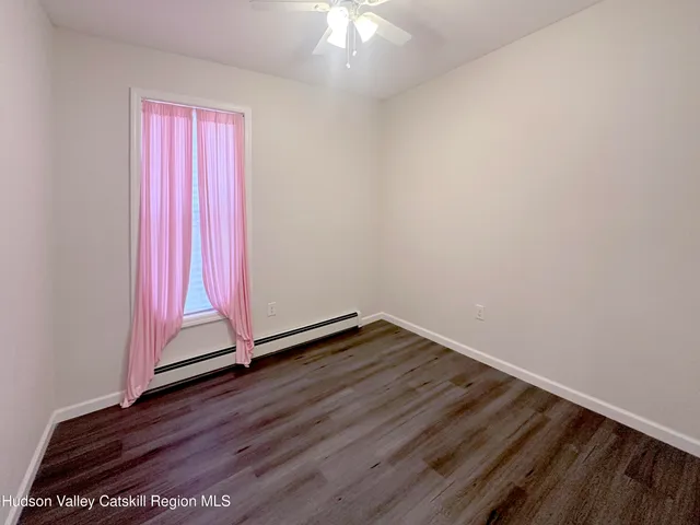 a view of a room with wooden floor and a window