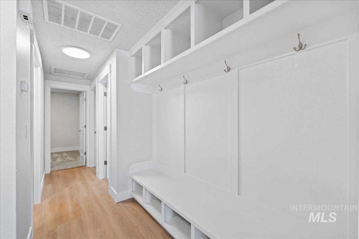 1309 West Maple Avenue Meridian, ID 83642 - Photo 12 of 50 Mudroom featuring light wood-type flooring and a textured ceiling