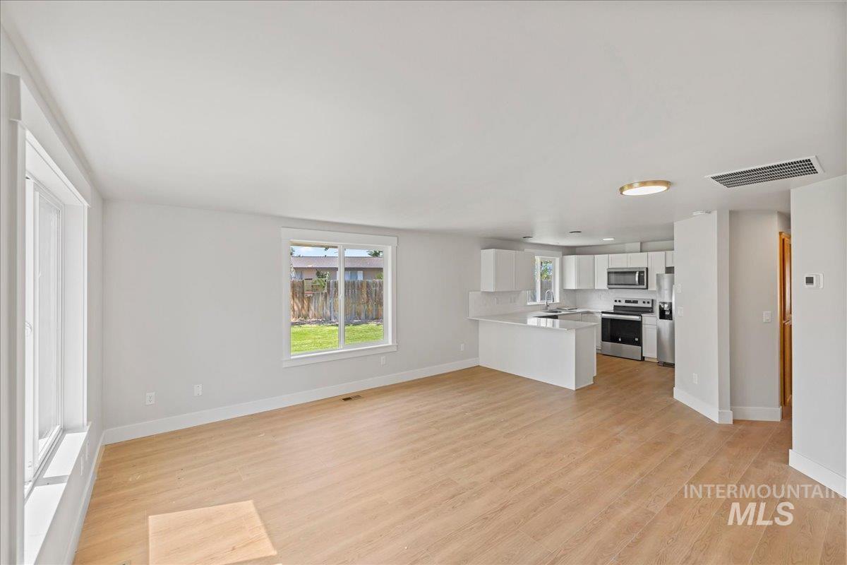 1309 West Maple Avenue Meridian, ID 83642 - Photo 26 of 50 Unfurnished living room with light wood finished floors and baseboards