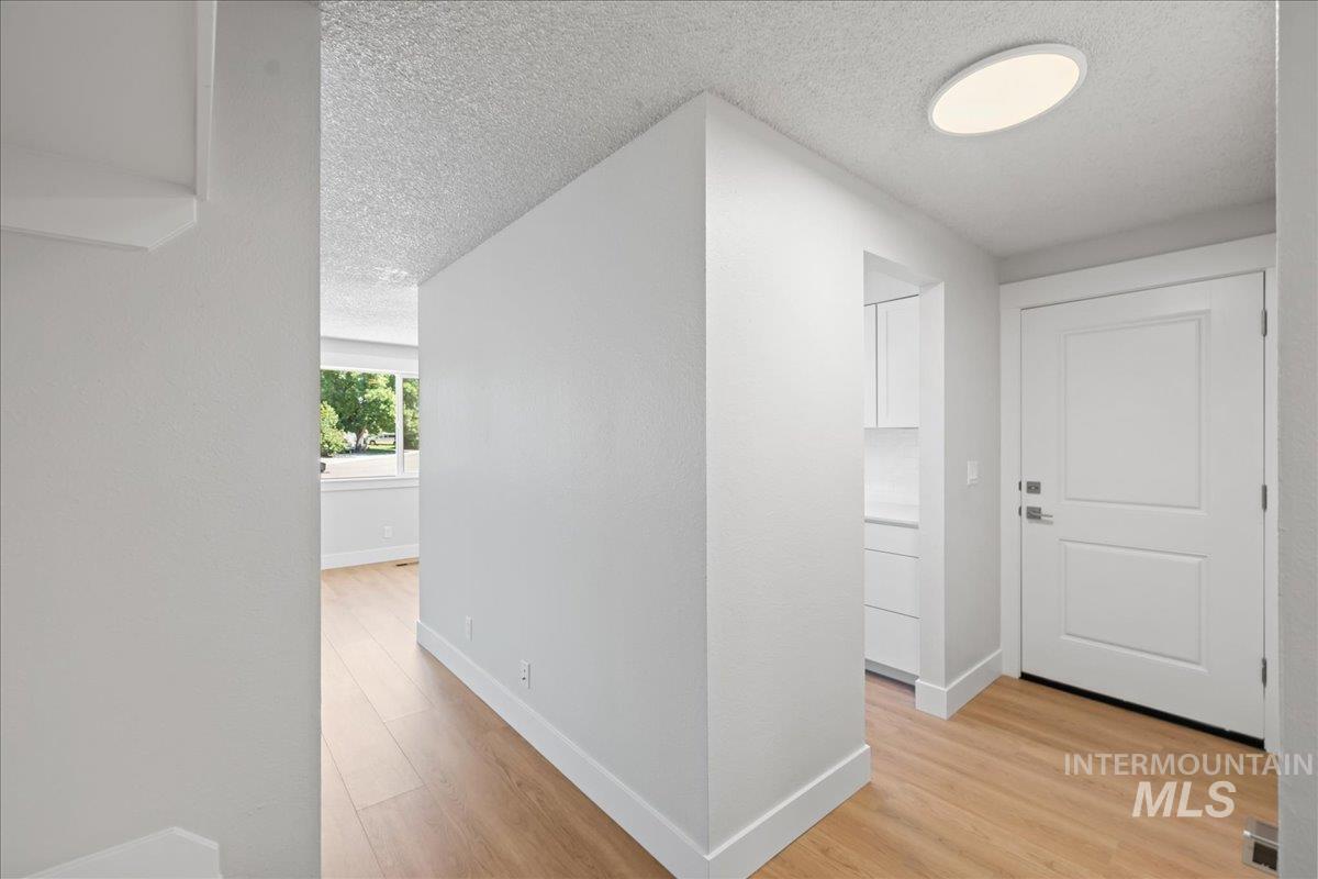 1309 West Maple Avenue Meridian, ID 83642 - Photo 3 of 50 Hallway with a textured ceiling and light wood-type flooring