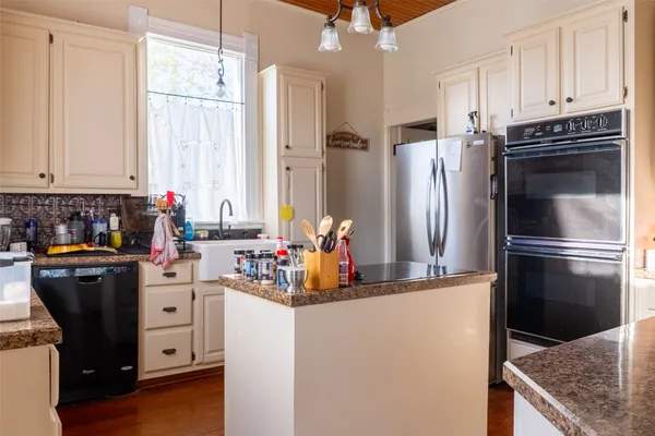 a kitchen with refrigerator and cabinets