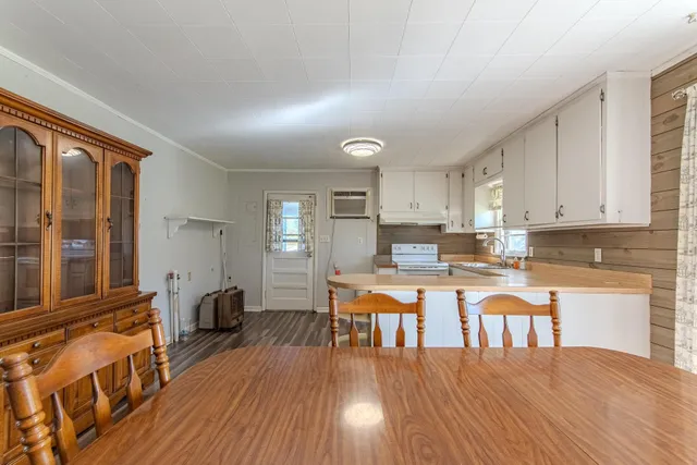 a kitchen with stainless steel appliances wooden floors and white cabinets