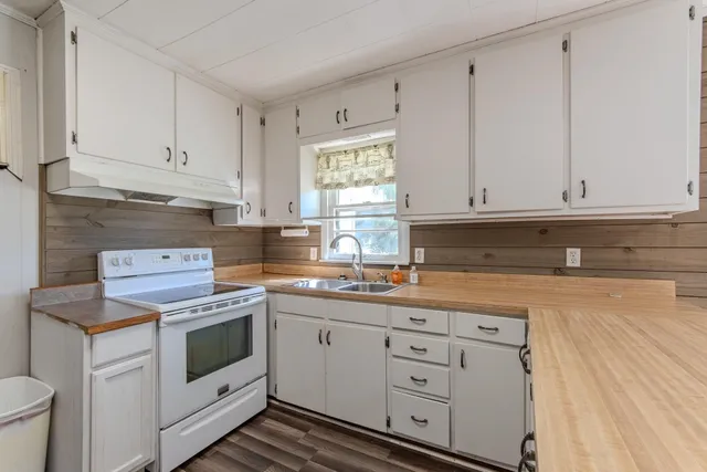 a kitchen with white cabinets and white appliances