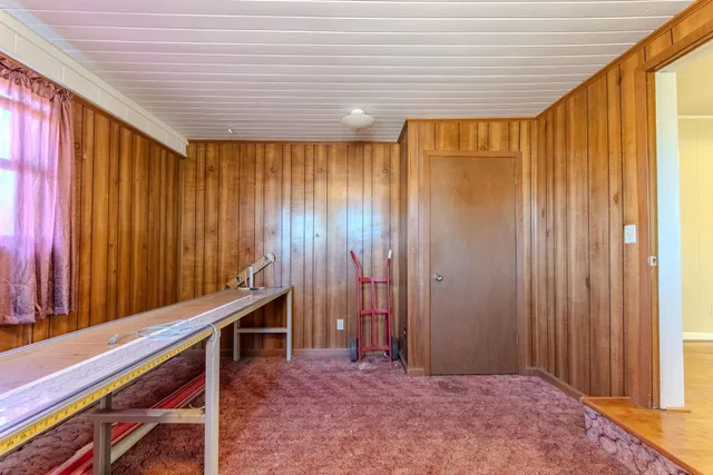 a view of a room with wooden walls and stairs