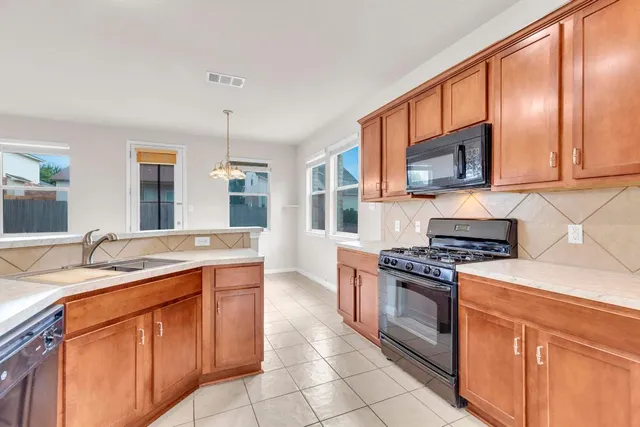 a kitchen with stainless steel appliances granite countertop a stove sink and microwave