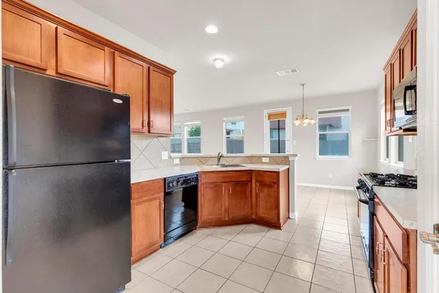 a kitchen with stainless steel appliances granite countertop a refrigerator and a sink