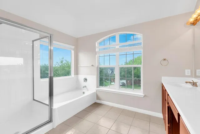 a bathroom with a tub sink and window