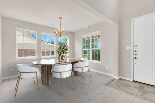 a dining room with furniture a chandelier and window
