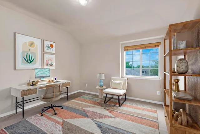 a work room with furniture a rug and a window