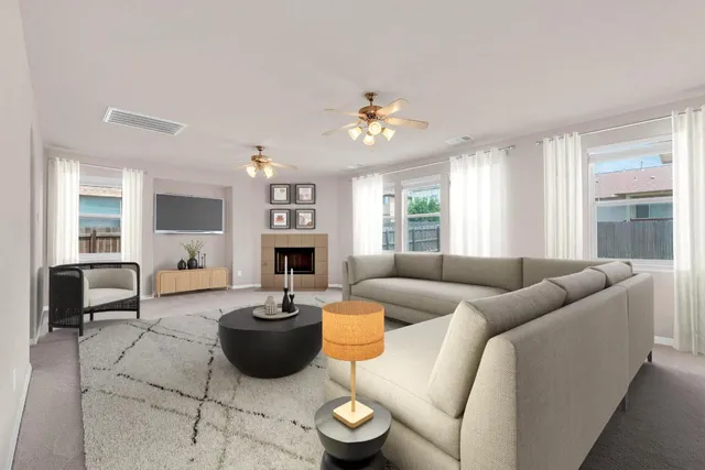 a living room with furniture a fireplace and a large window