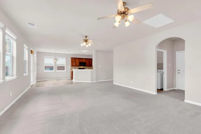 a view of a livingroom with a ceiling fan and window