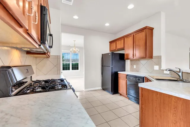 a kitchen with stainless steel appliances granite countertop a stove a sink and a refrigerator